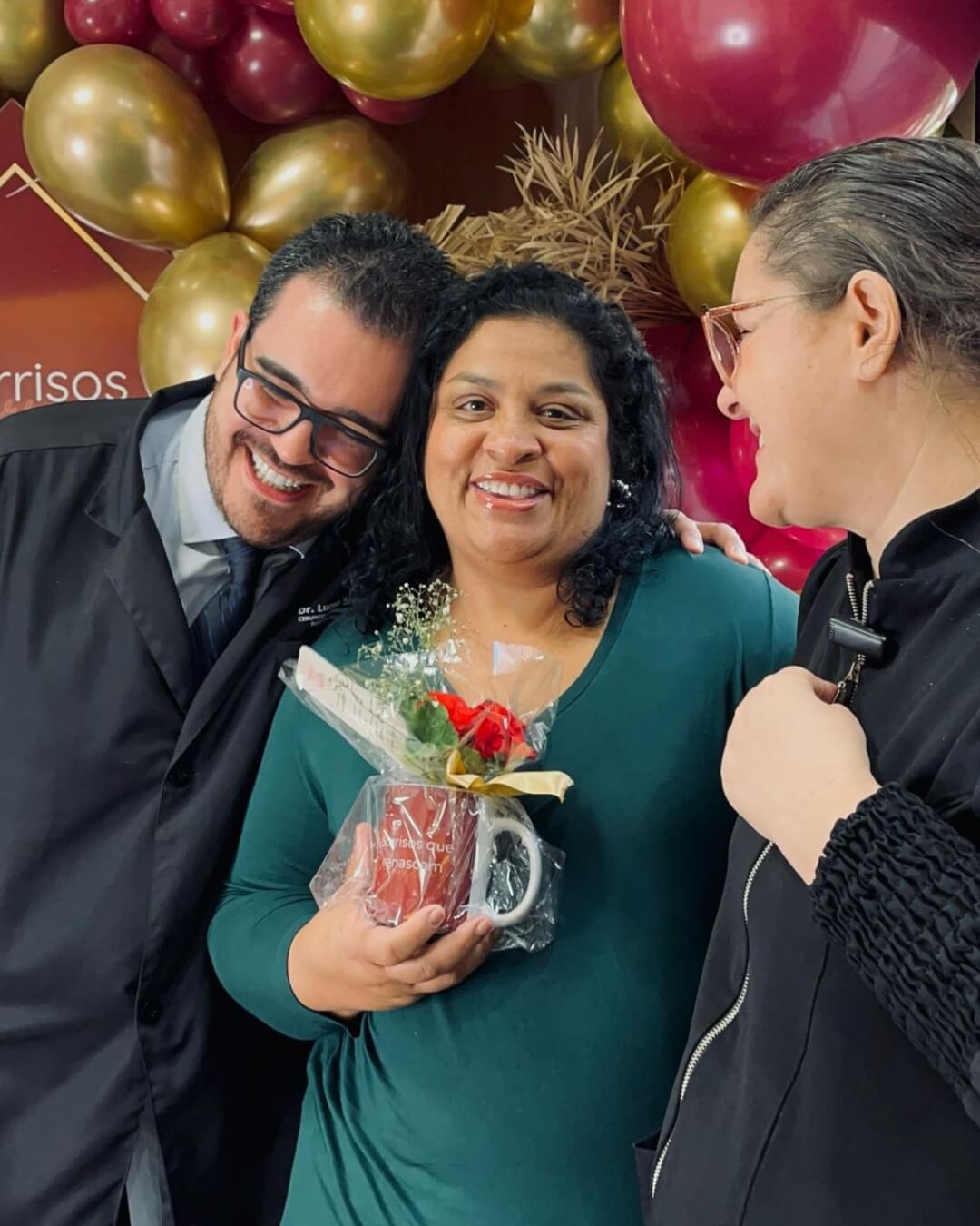 Dr Silveira e outra doutora da Clínica Silveira Odontologia em Franca abraçando paciente que acaba de realizar o protocolo dentário. Melhor Dentista em Franca - SP