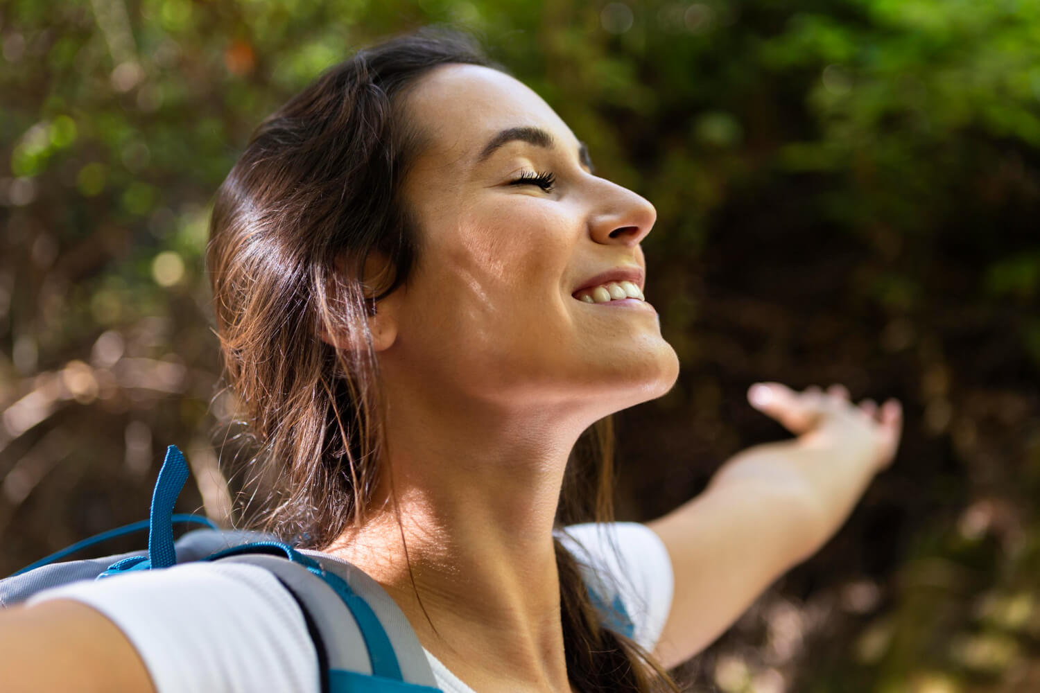 Mulher sorridente de perfil exibindo queixo alinhado ao ar livre. Cirurgia de mentoplastia em Franca SP na Silveira Odontologia.