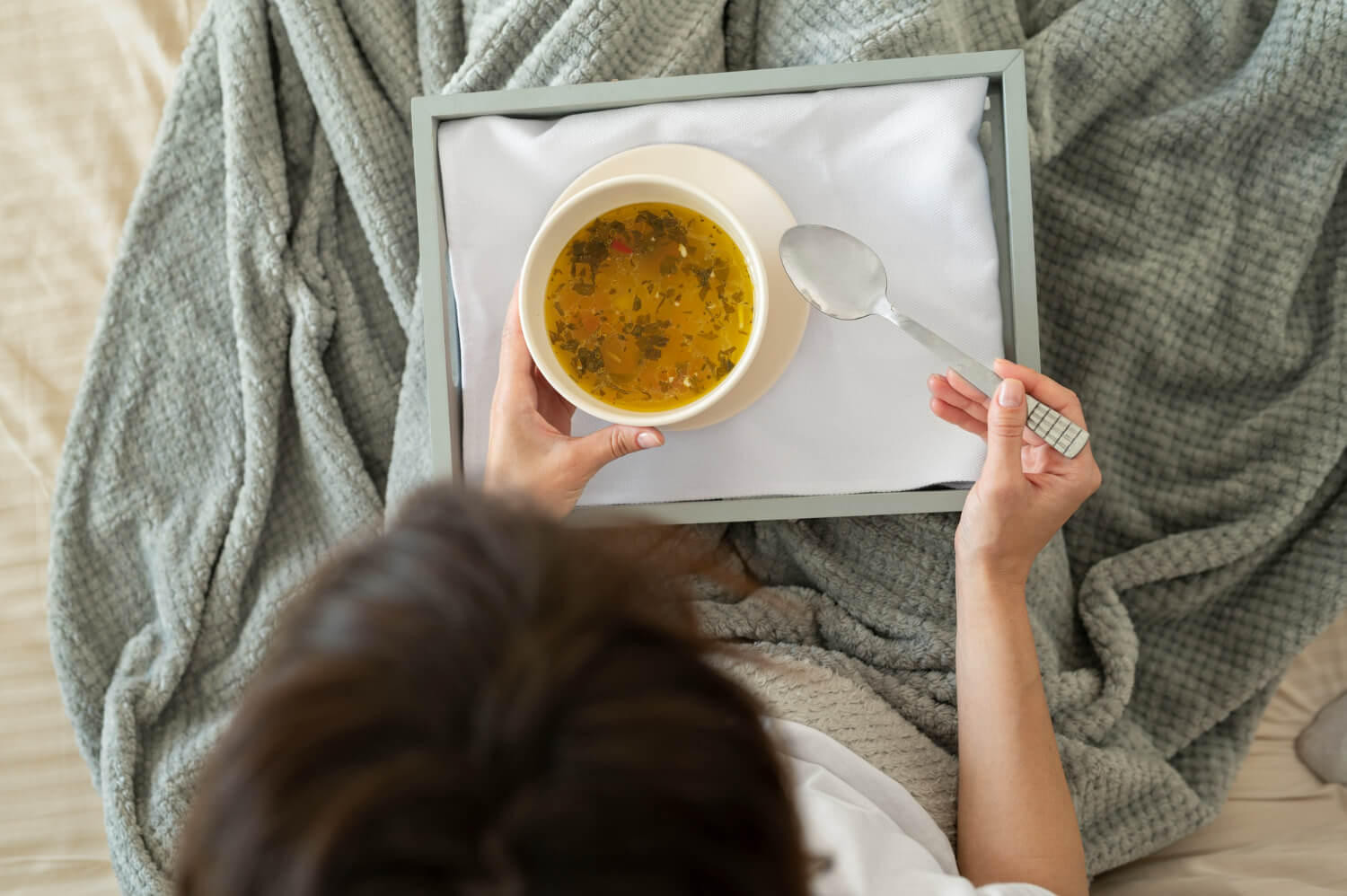 Pessoa segurando bandeja com tigela de sopa para alimentação no pós-operatório da cirurgia ortognática na Silveira Odontologia em Franca SP.